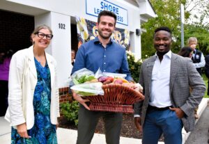 From left Shore Legal Access Executive Director Meredith Lathbury-Girard, Esq., stands with Ross Benincasa and Sam Shoge of River and Roads. Benincasa won a basket of fresh produce from Cottingham Farms at the nonprofit’s Sept. 28 grand reopening in Easton, Maryland.