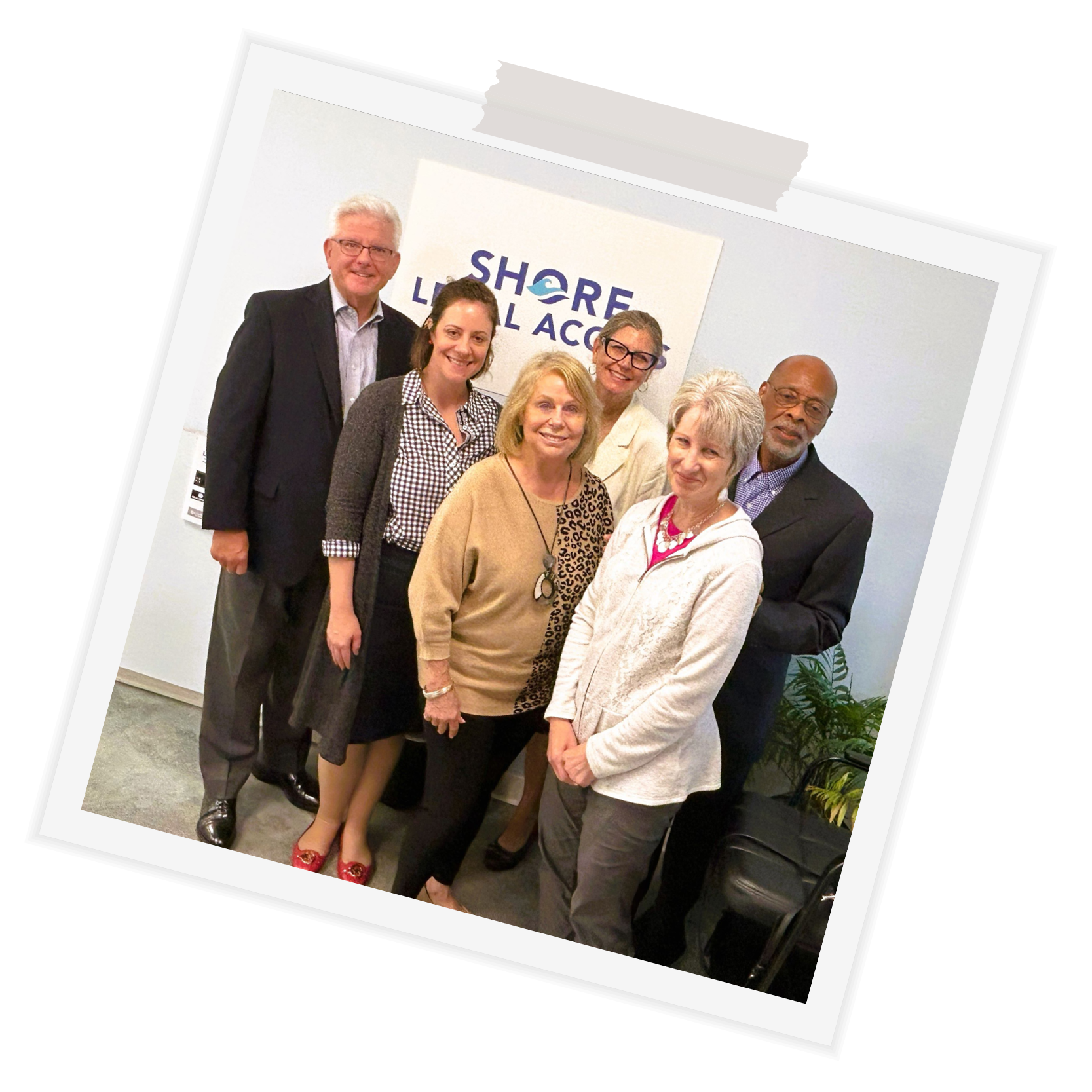 multicultural-board-members-pose-in-front-of-shore-legal-access-logo